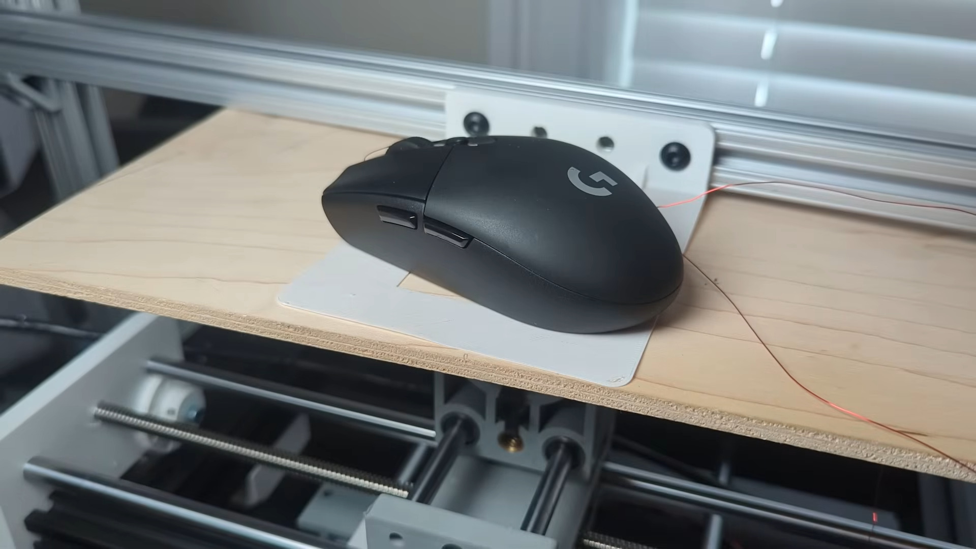 Une souris Logitech Gaming au sommet d'un appareil AIMBOT physique